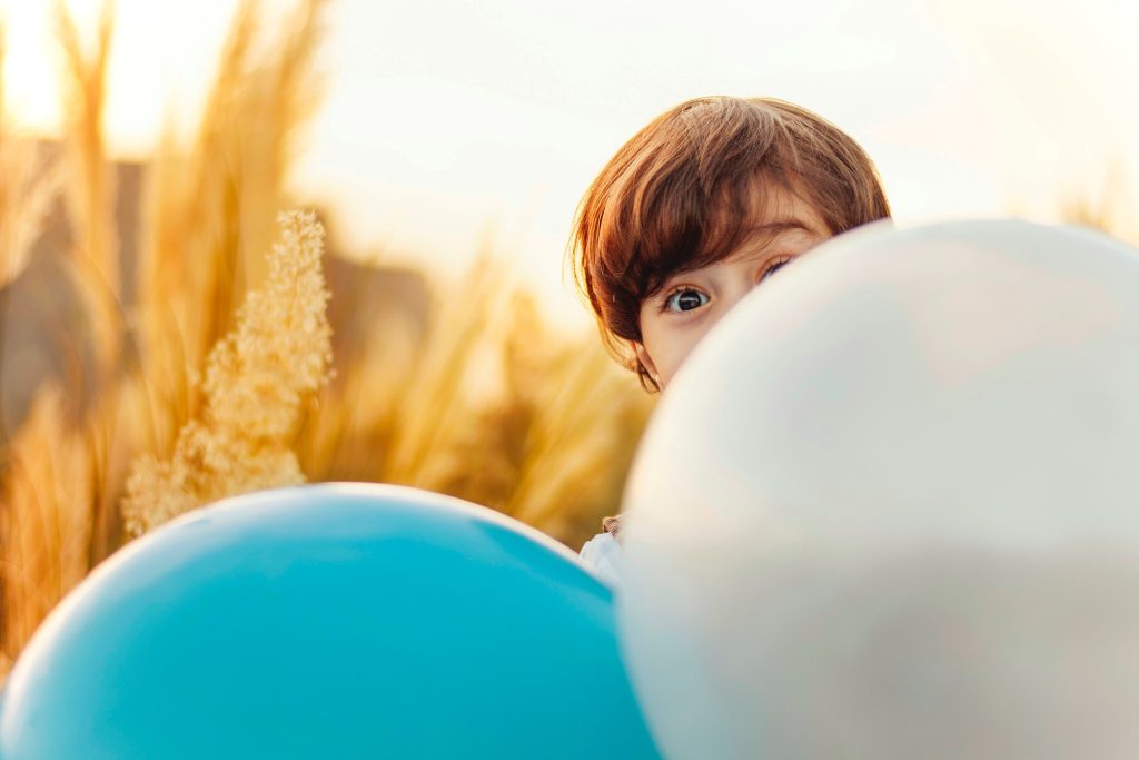 Boy hiding behind balloons