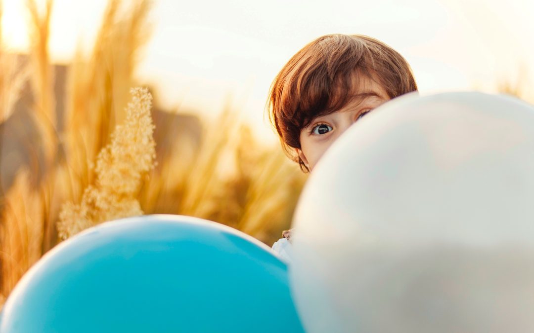 Boy hiding behind balloons